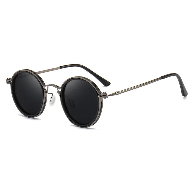 Lunettes de soleil rondes noires avec monture métallique argentée, branches fines et verres teintés, style rétro tendance pour homme et femme.