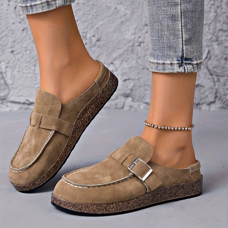 Chaussures mocassins beiges pour femmes, semelle en liège, portées avec un jean ajusté. Style décontracté, tendance mode, confort quotidien.