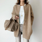 Femme portant un manteau en laine beige, t-shirt blanc, jean gris, sac à main taupe. Mode automne, style décontracté chic, accessoires élégants.