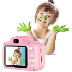 Appareil photo numérique rose pour enfants affichant une fille souriante avec de la peinture verte sur le visage et les mains. Idéal pour la créativité enfantine.