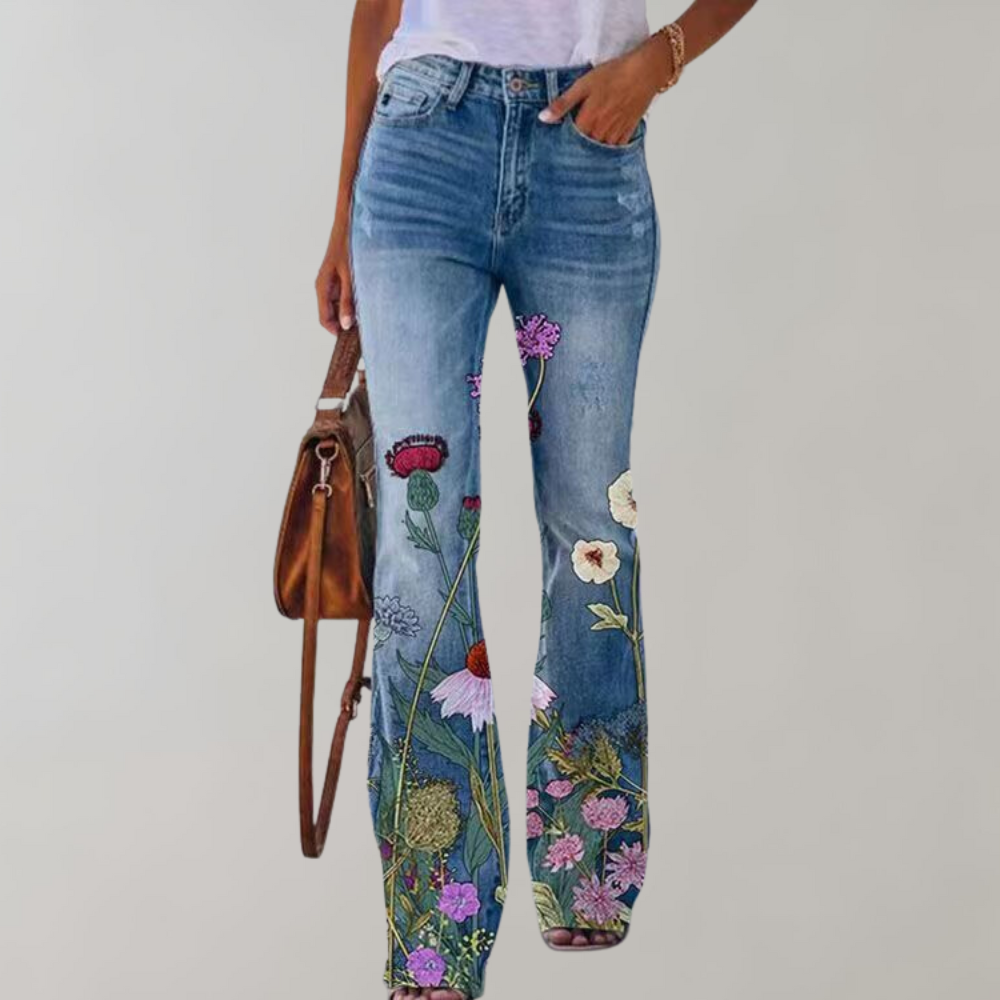 Jeans bleus à fleurs brodées, femme, style bohème, sac en cuir marron, mode décontractée, tendance, fond blanc.