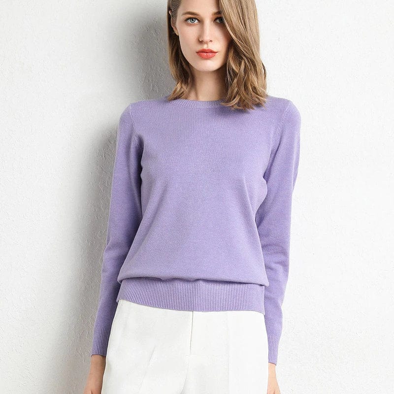 Dame portant un pull violet élégant, manches longues, col rond, assorti à un pantalon blanc. Mode féminine chic, style décontracté.