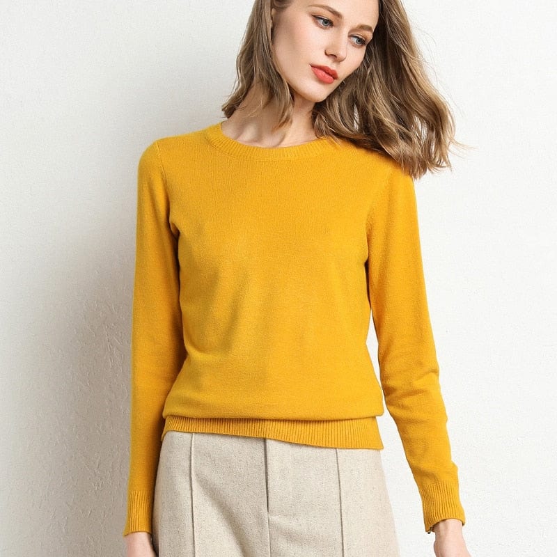 Femme portant un pull jaune vif, manches longues, avec jupe beige. Mode automne, style élégant et décontracté. Fond blanc minimaliste.