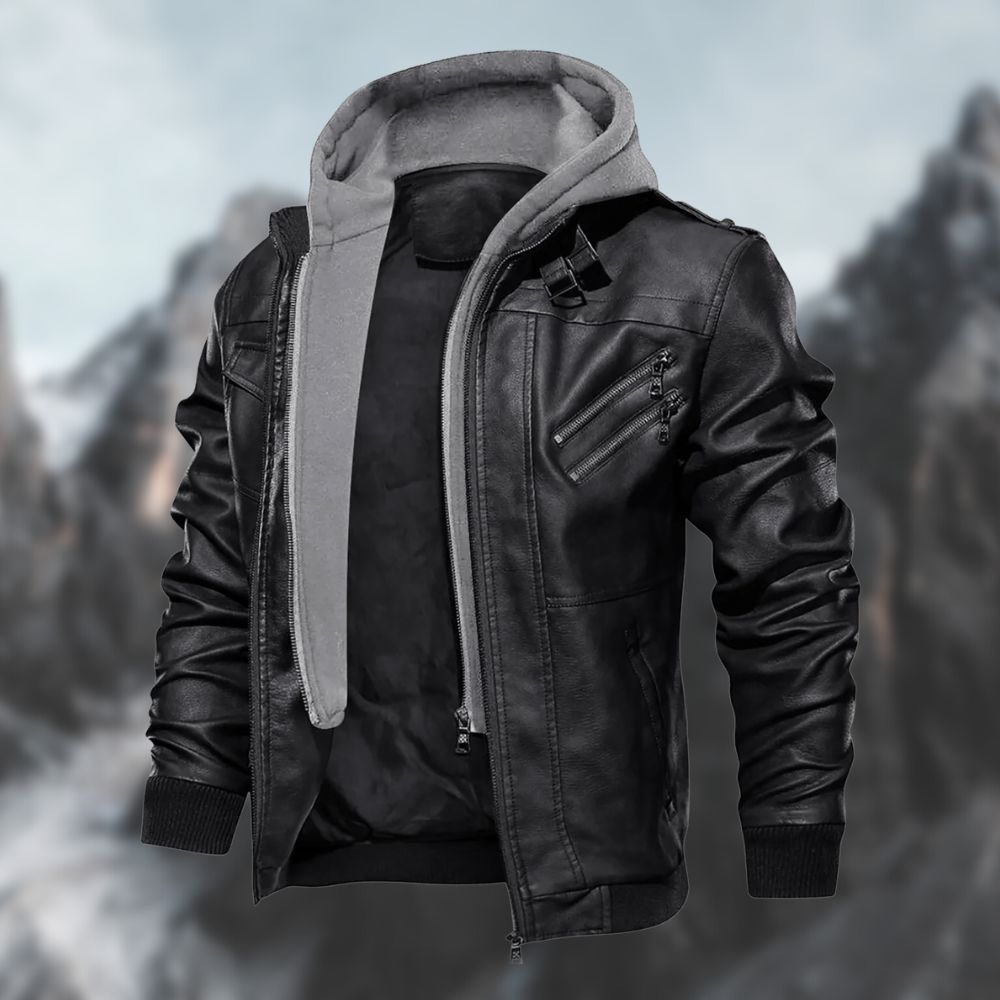 Veste en cuir noir avec capuche grise, style moderne et urbain, devant un fond de montagnes floues. Mode homme, tendance automne-hiver.
