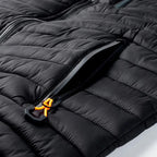 Veste matelassée noire avec fermeture éclair, poche zippée et tirette orange. Mode hiver, vêtement chaud, design moderne et fonctionnel.