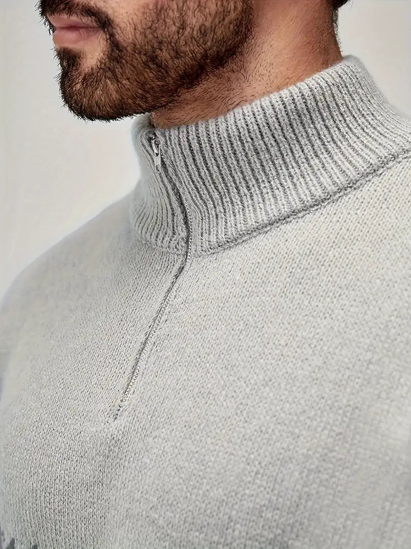 Homme portant un pull gris à col zippé, texture en maille, style décontracté et moderne, mode masculine automne-hiver, gros plan.