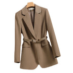 Blazer femme beige élégant avec ceinture, col à revers, poches à rabat, style chic et moderne, idéal pour tenues professionnelles et décontractées.