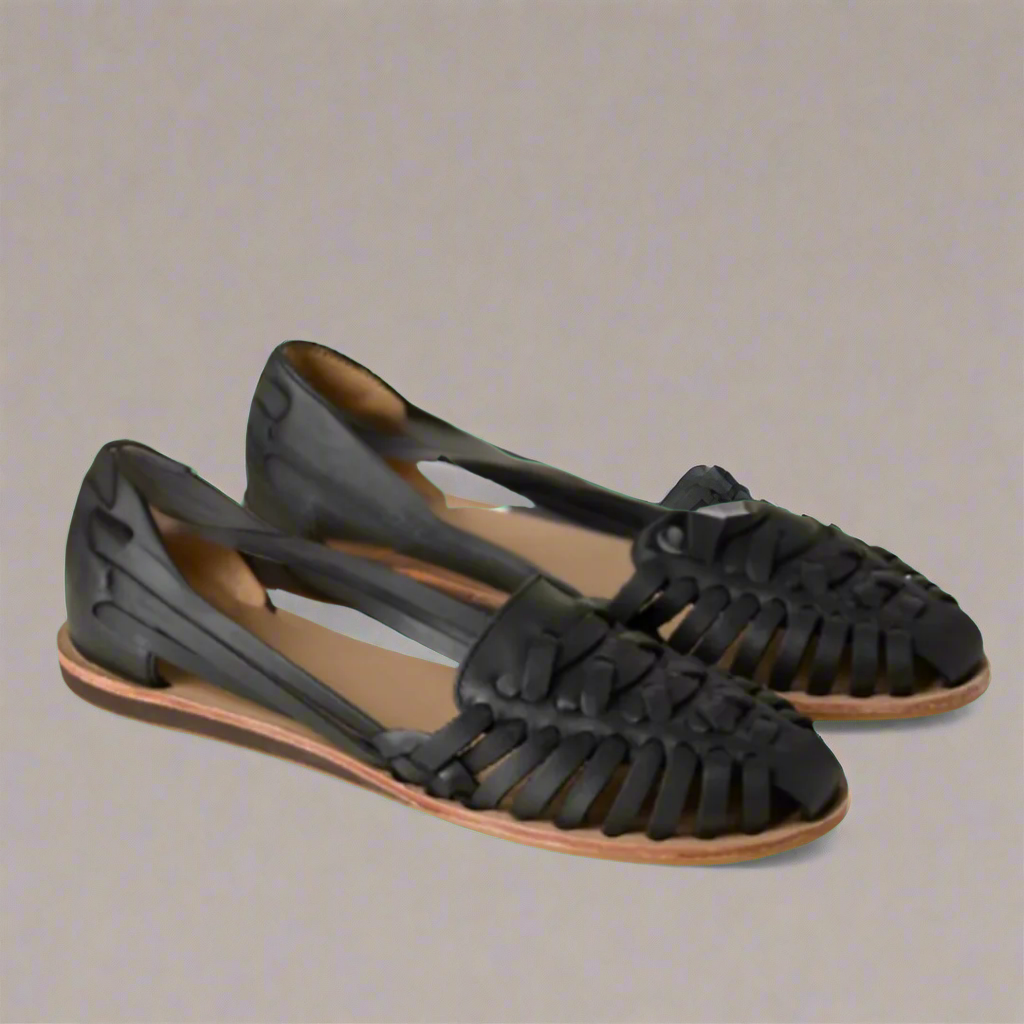 Paire de sandales huaraches en cuir noir pour femme, design tressé artisanal, semelle plate, style bohème chic, mode été confortable.
