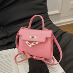 Sac à main rose élégant sur canapé noir, design moderne avec fermoir métallique, idéal pour mode féminine et accessoires tendance.