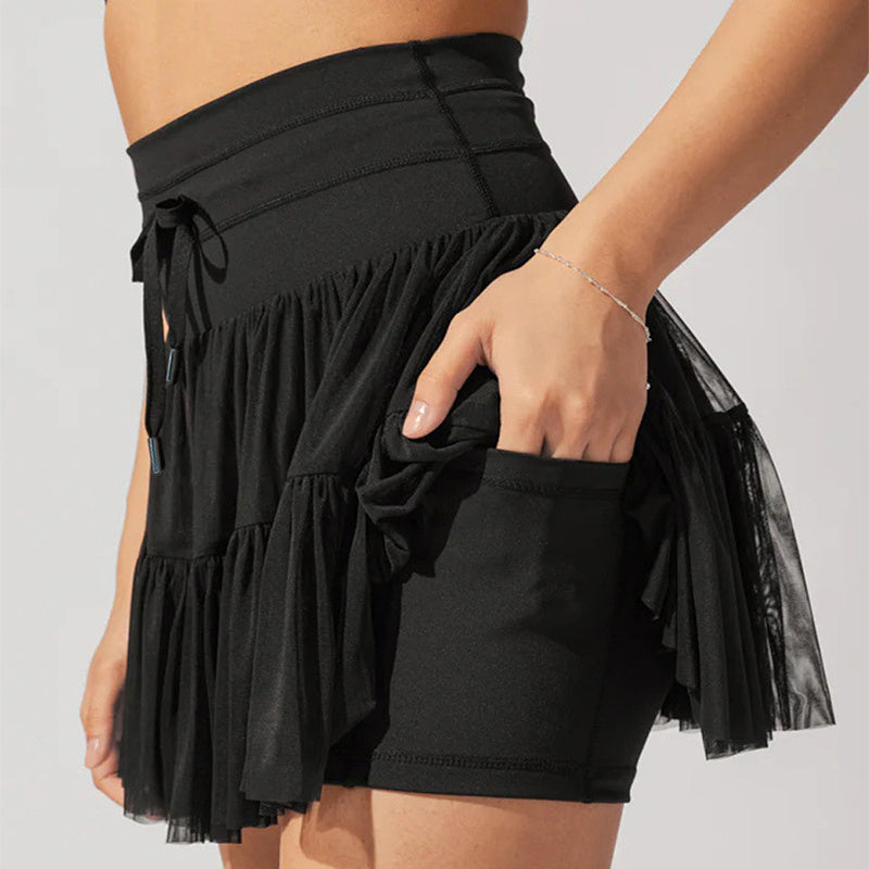 Jupe-short noire en tulle pour femme, taille haute, avec poches, design élégant et moderne, tenue de sport ou de danse, mode féminine tendance.