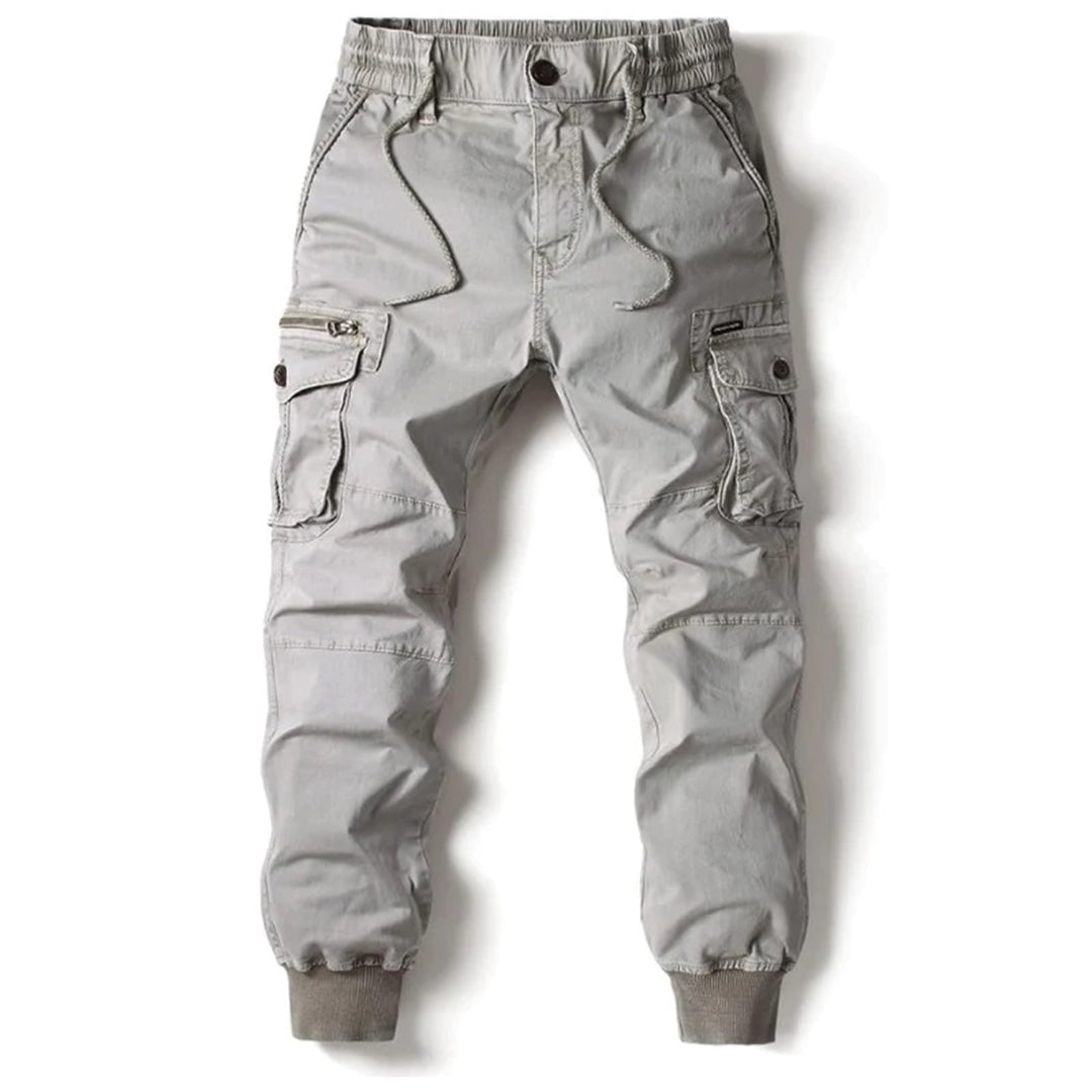 Pantalon cargo gris pour homme avec poches latérales, taille élastique et cordon de serrage. Style décontracté, idéal pour la mode urbaine.