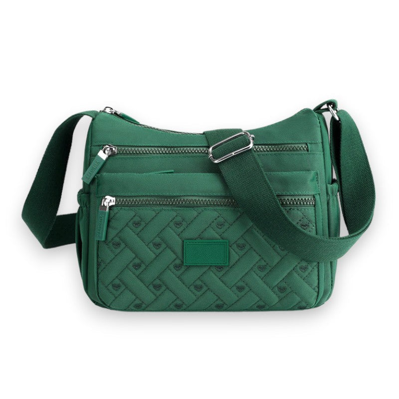 Sac bandoulière vert en tissu matelassé avec poches zippées, design élégant et moderne, idéal pour femme, accessoire mode tendance.