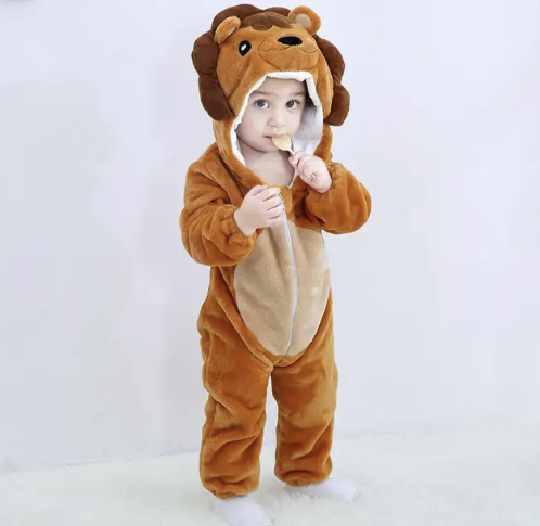 Enfant en pyjama lion en peluche marron, tenant un biscuit. Costume animalier mignon pour bébé, idéal pour déguisement ou pyjama party.