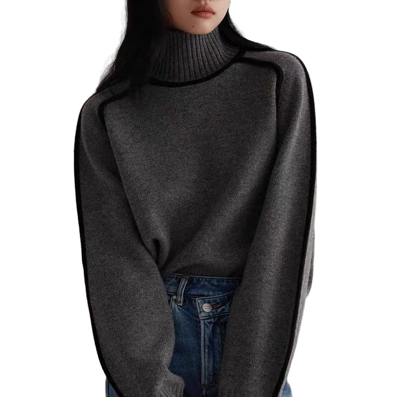 Femme portant un pull gris à col roulé et manches longues, associé à un jean bleu. Mode automne-hiver, style décontracté et élégant.