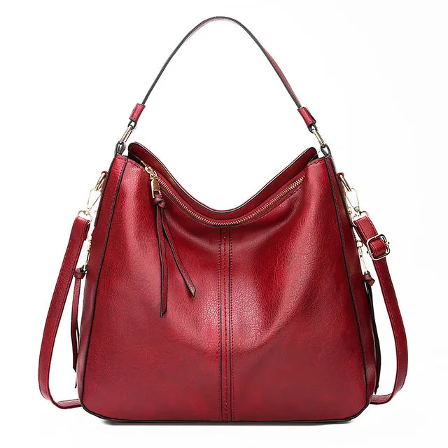 Sac à main en cuir rouge élégant avec bandoulière réglable, fermeture éclair dorée et design moderne. Accessoire mode femme chic et tendance.