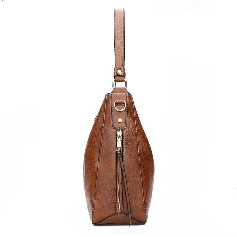 Sac à main en cuir marron avec bandoulière, fermeture éclair dorée et design élégant. Accessoire mode femme, tendance et chic.