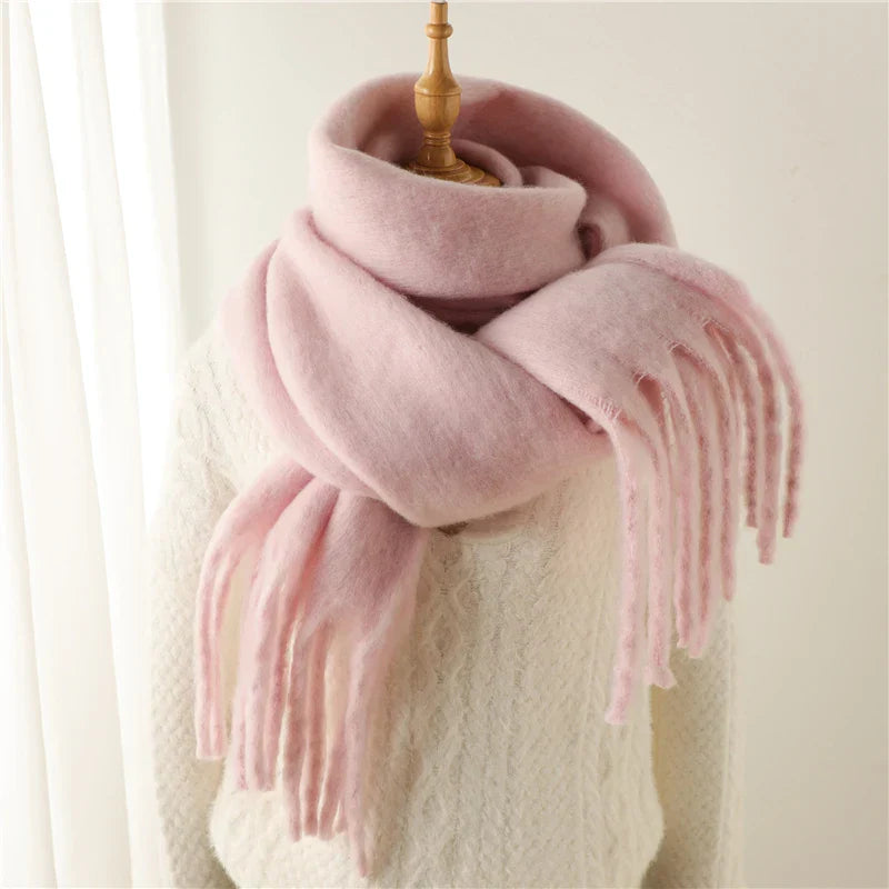 Écharpe en laine rose douce sur mannequin, texture moelleuse, franges élégantes, accessoire mode hiver, confort et chaleur, style tendance.