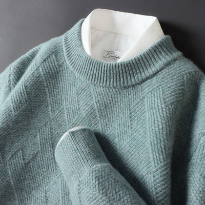 Pull en laine vert menthe avec motif géométrique, col rond, superposé sur une chemise blanche. Mode hiver élégante et confortable.