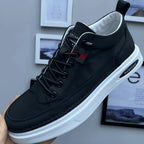 Chaussure de sport noire élégante avec semelle blanche épaisse, lacets noirs, et détails modernes, tenue en main devant un mur décoré de cadres.