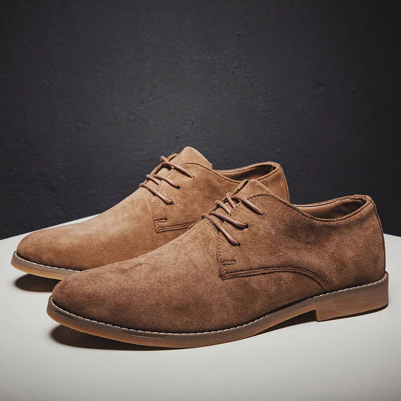 Chaussures derby en daim marron pour homme, élégantes et modernes, posées sur une table blanche, idéales pour un look chic et décontracté.