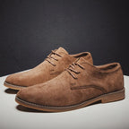 Chaussures derby en daim marron pour homme, élégantes et modernes, posées sur une table blanche, idéales pour un look chic et décontracté.