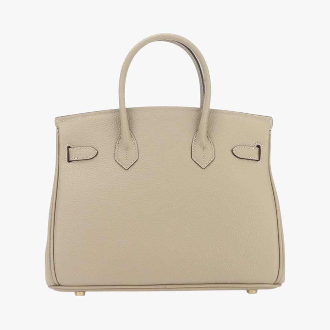 Sac à main beige en cuir texturé, style Birkin, avec poignées doubles et pieds métalliques dorés. Accessoire de mode élégant et luxueux.