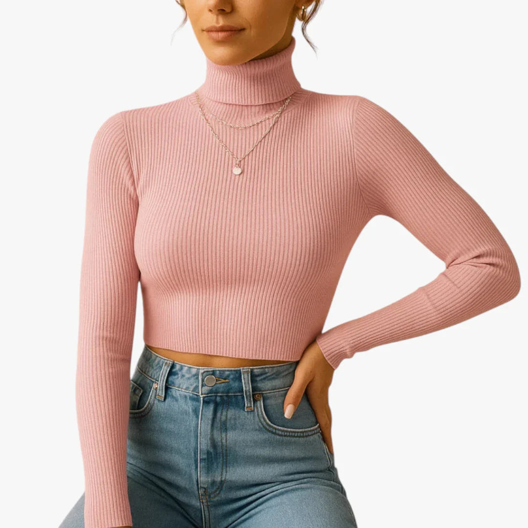 Femme portant un pull rose à col roulé et manches longues, associé à un jean taille haute bleu. Style mode décontracté et élégant.