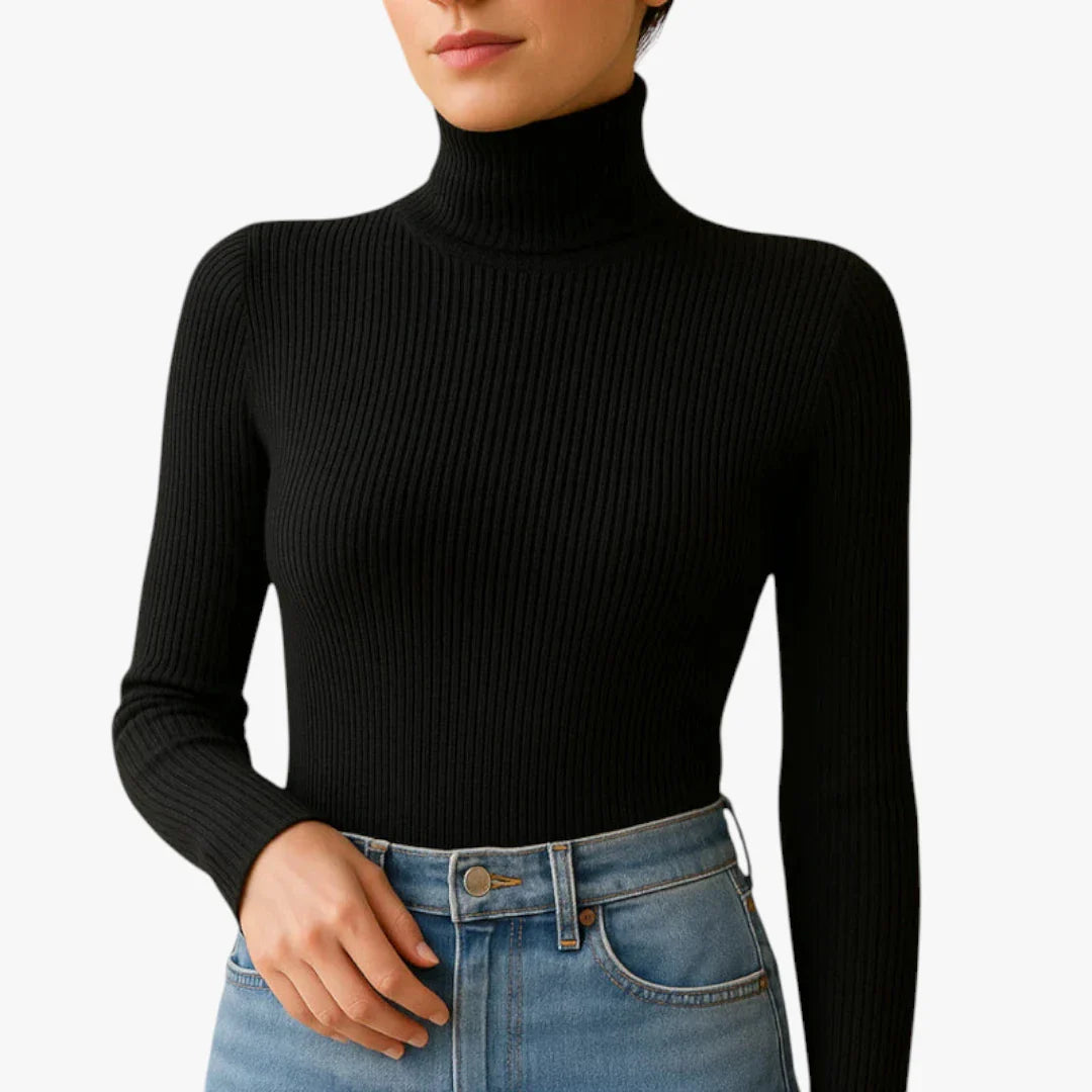 Femme portant un pull col roulé noir côtelé et un jean bleu taille haute. Mode automne-hiver, style élégant et décontracté.