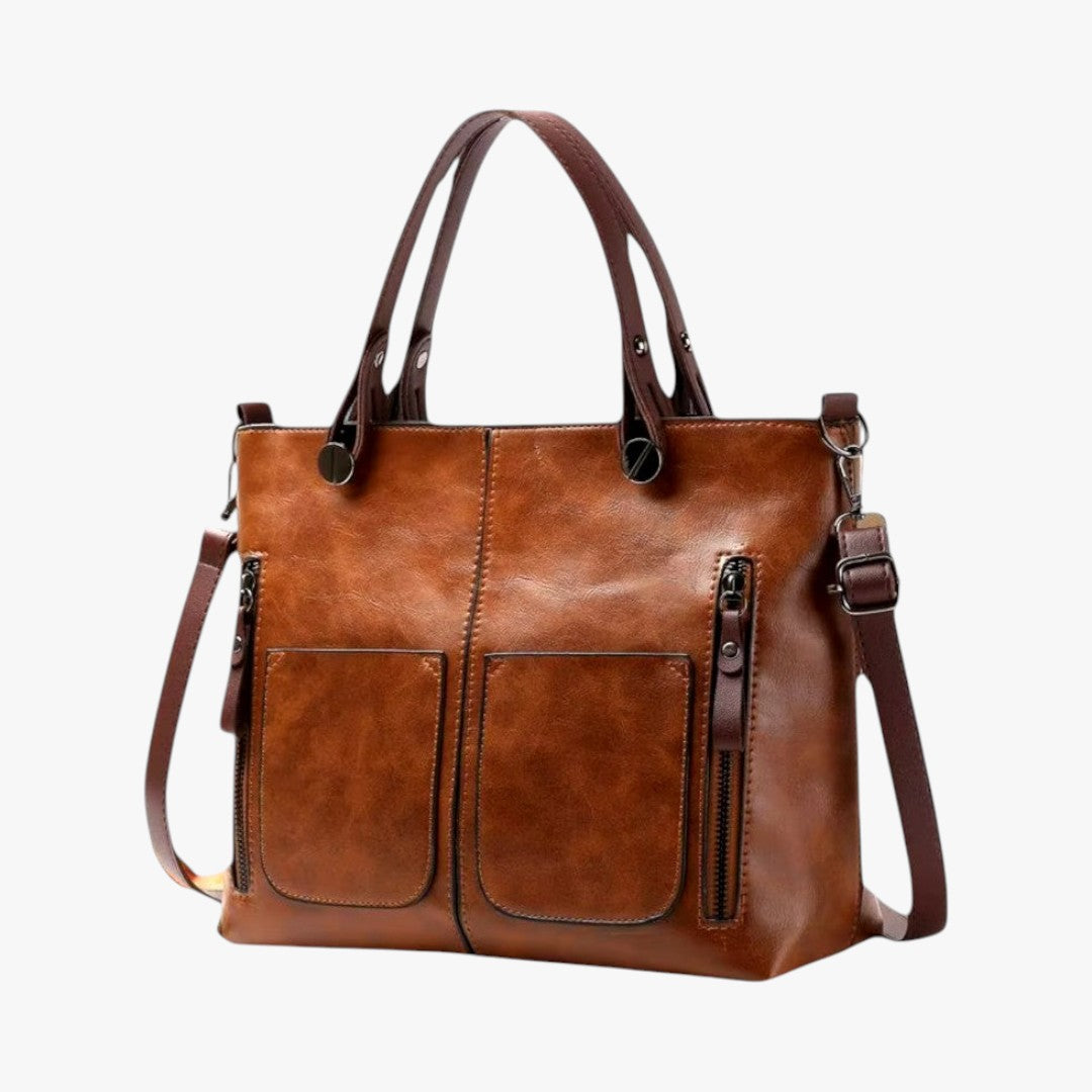 Sac à main en cuir marron avec deux poches avant et bandoulière amovible. Élégant et pratique, idéal pour un usage quotidien.