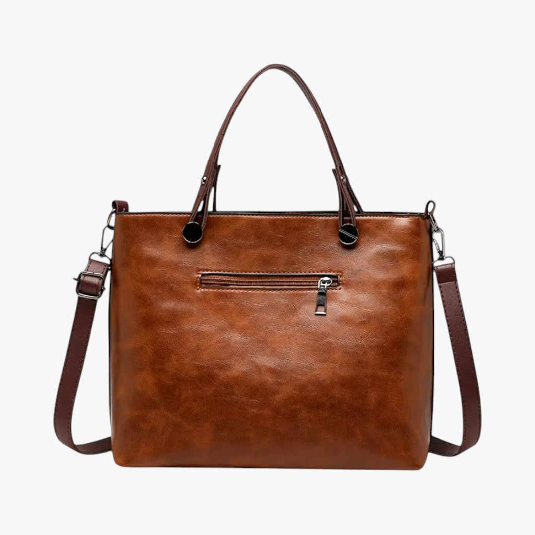 Sac à main en cuir marron élégant avec bandoulière amovible, fermeture éclair, poignées robustes. Accessoire mode femme chic et pratique.