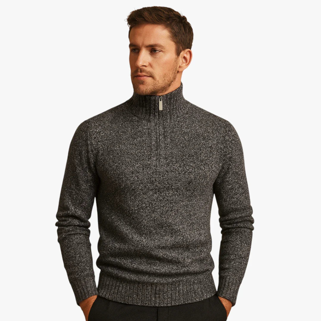 Homme portant un pull gris à col zippé, style décontracté et élégant, mode masculine automne-hiver, vêtement chaud et confortable.