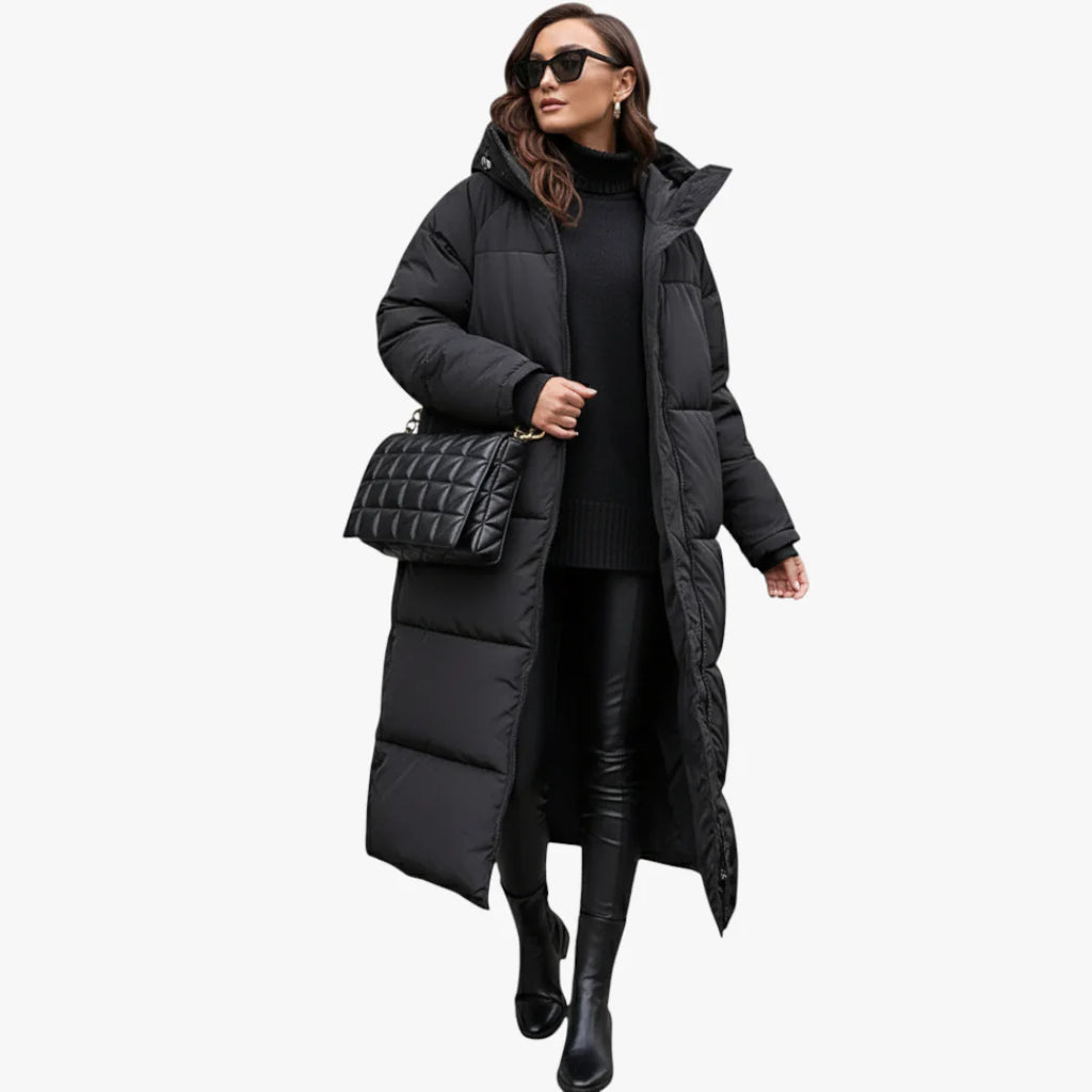 Femme portant un long manteau doudoune noir, pull noir, leggings en cuir, bottes noires, lunettes de soleil et sac à main matelassé noir.