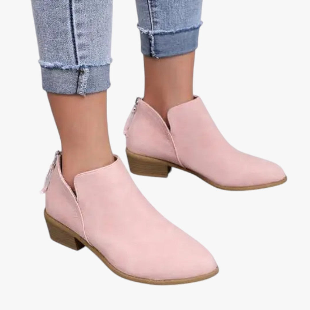 Bottines roses en daim pour femme, talon bas, portées avec un jean déchiré. Chaussures tendance automne, style décontracté et élégant.