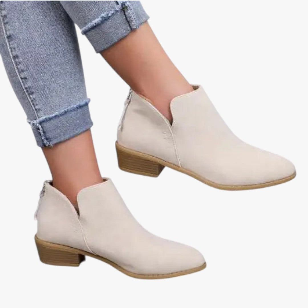 Bottines blanches en cuir avec talon bas, portées avec un jean retroussé. Chaussures tendance pour femme, style décontracté et moderne.