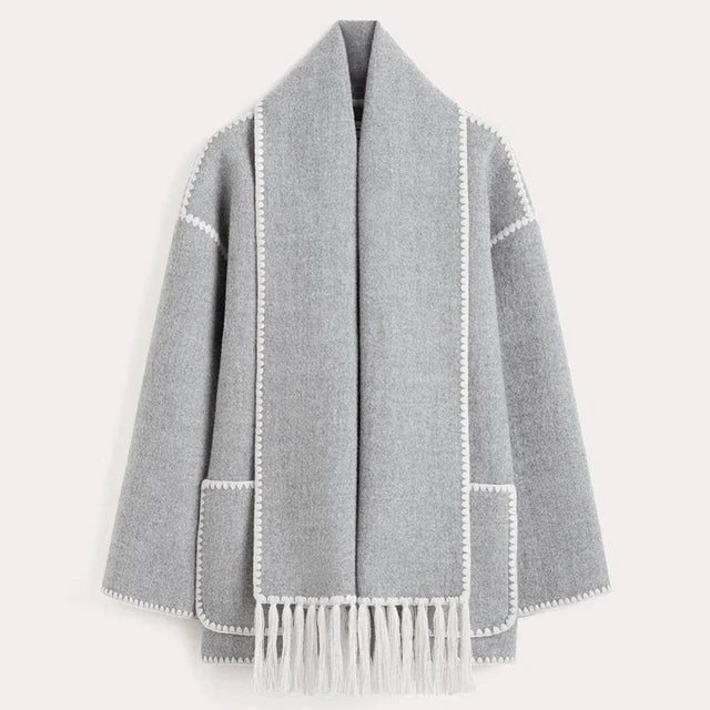 Manteau gris en laine avec franges, bordures blanches, style élégant et moderne, idéal pour l'hiver. Mode femme, vêtement chaud et tendance.