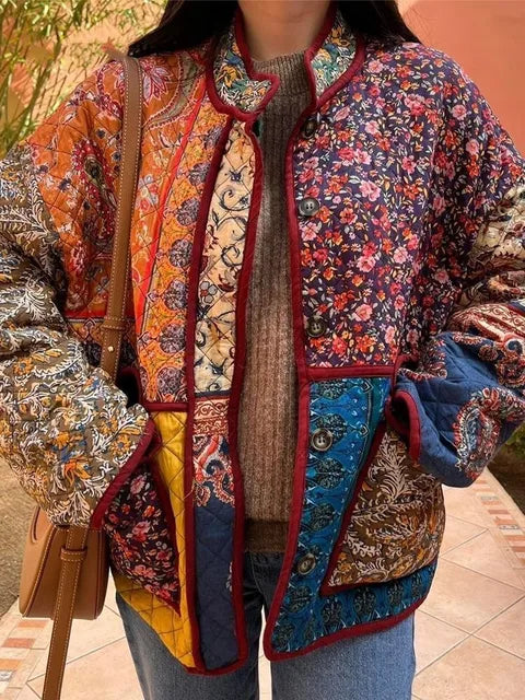 Veste patchwork colorée pour femme avec motifs floraux et géométriques, portée sur un pull marron, sac à main beige en cuir. Mode bohème chic.