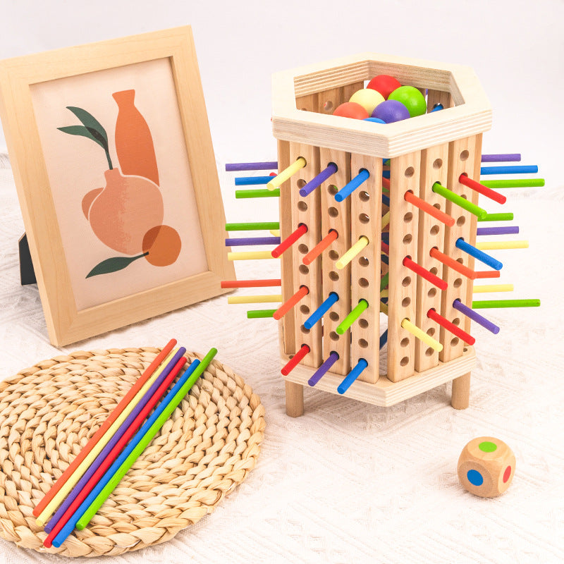 Jeu de société en bois avec bâtons colorés et billes, encadré d'une illustration artistique. Jouet éducatif pour enfants, développement de la motricité.