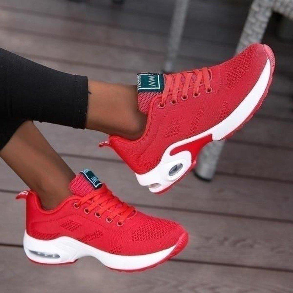 Chaussures de sport rouges pour femme avec semelle blanche, design moderne et respirant, idéales pour la course et le fitness.