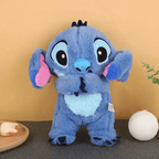 Peluche Stitch bleue debout sur une table, oreilles roses, fond beige, décoration minimaliste. Jouet Disney populaire, cadeau enfant.