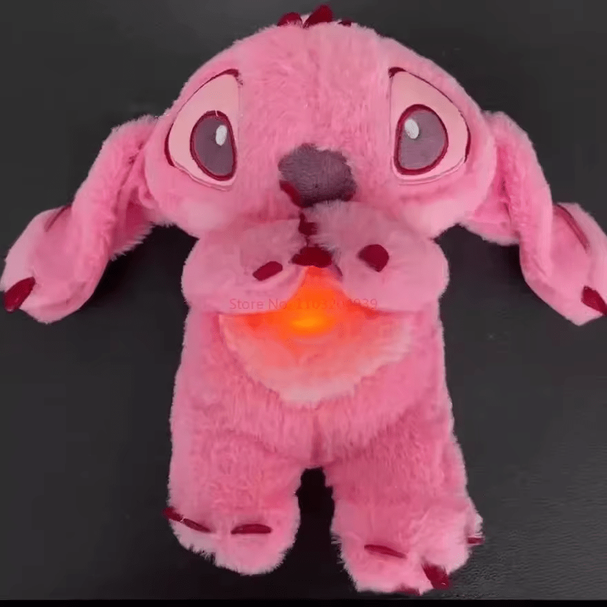 Peluche rose en forme de chien avec oreilles tombantes et yeux expressifs, posée sur fond noir. Jouet doux et mignon pour enfants.