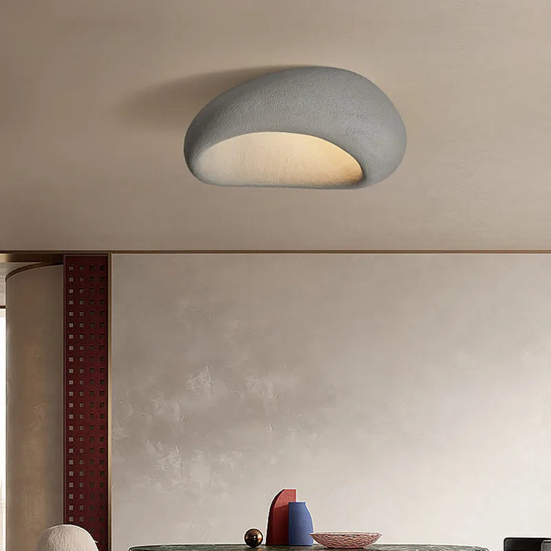 Plafonnier moderne en forme de galet gris, éclairage LED doux, design minimaliste, intérieur contemporain, décoration plafond élégante.