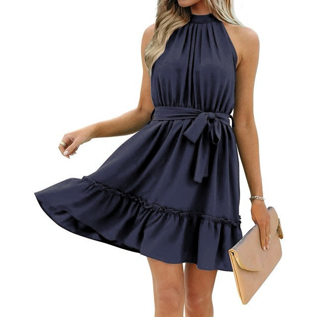 Robe bleue sans manches élégante avec ceinture, tenue d'été chic pour femme, accessoirisée d'une pochette beige. Mode féminine tendance.