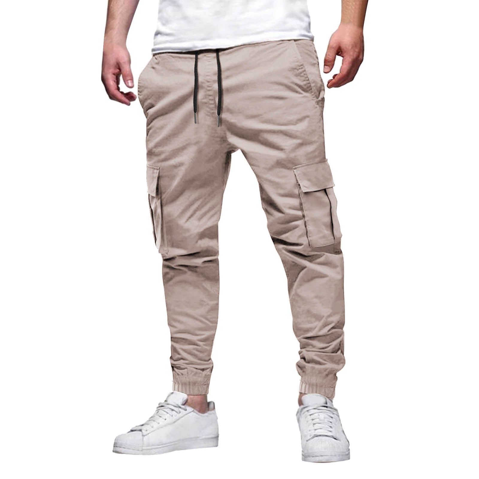 Pantalon cargo beige pour homme, style décontracté, avec poches latérales, cordon de serrage, porté avec des baskets blanches. Mode urbaine tendance.