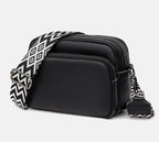 Sac bandoulière noir en cuir avec sangle à motifs géométriques noir et blanc. Accessoire mode tendance, pratique pour un style chic et moderne.