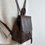 Sac à dos en cuir marron foncé sur mannequin, design minimaliste, mode tendance, accessoire élégant, idéal pour un style urbain et chic.