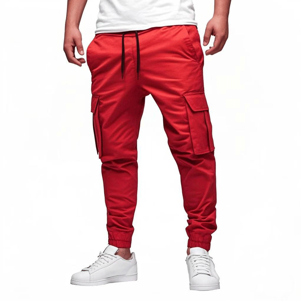 Pantalon cargo rouge pour homme avec poches latérales, cordon de serrage noir, porté avec des baskets blanches. Mode urbaine décontractée.