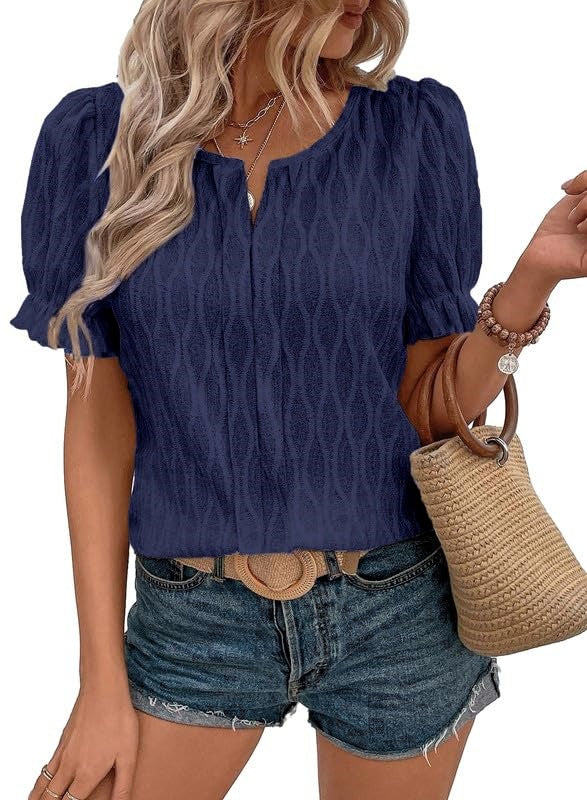 Femme en blouse bleue à manches courtes, portant un short en jean et un sac en paille. Mode estivale décontractée, style tendance.