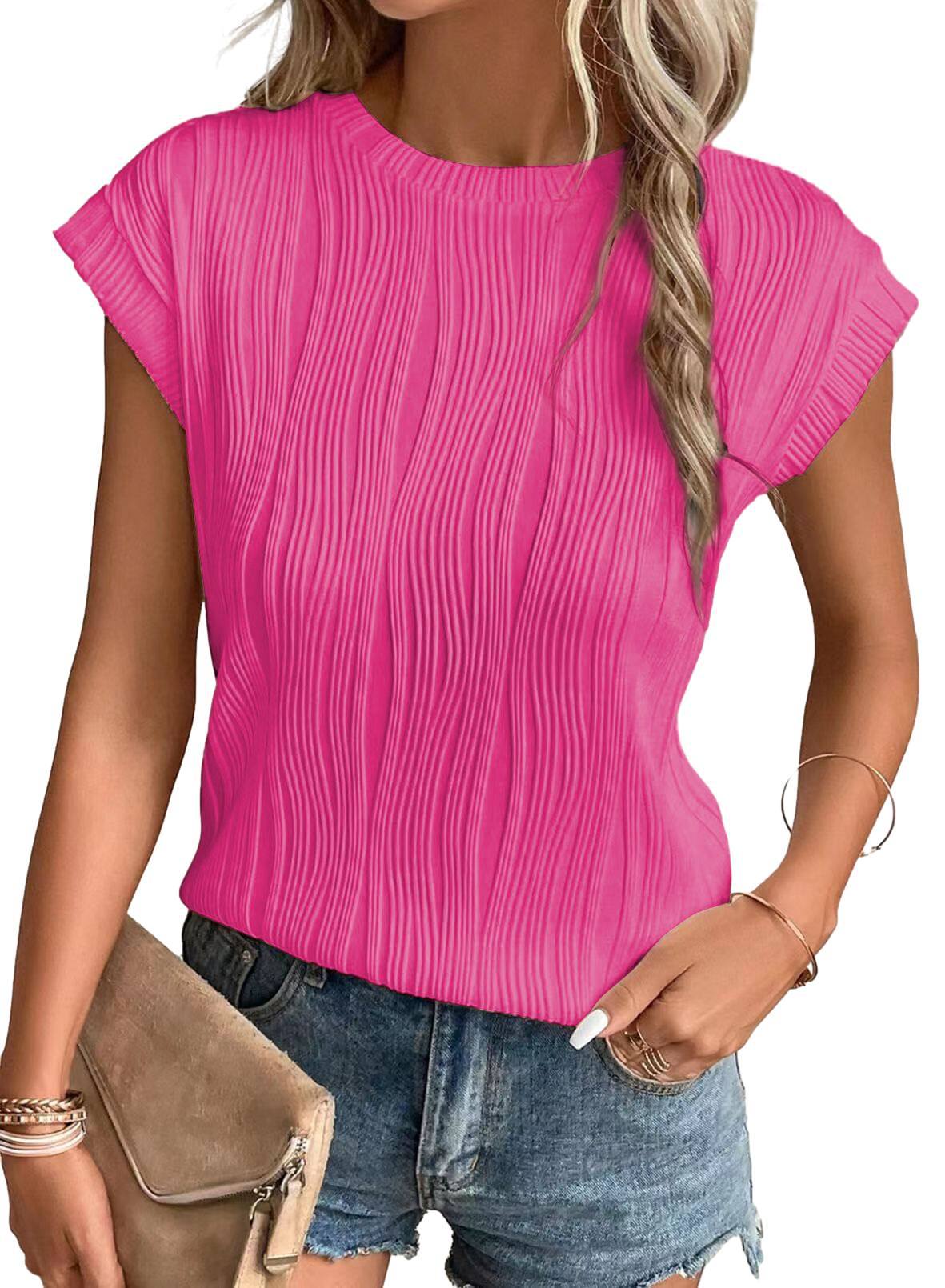 Femme portant un t-shirt rose texturé à manches courtes, associé à un short en jean. Mode estivale, tenue décontractée, style tendance.