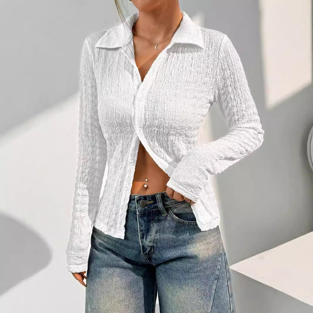 Femme portant une chemise blanche texturée et un jean décontracté, posant dans un intérieur moderne. Mode féminine, style décontracté, tendance 2023.