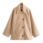 Manteau beige en laine pour femme, style classique avec col large et boutons noirs, poches avant. Mode automne-hiver, élégant et chaud.